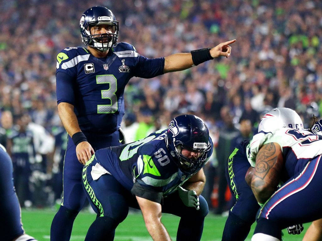 Russell Wilson Pointing While Team Is Crouching Wallpaper
