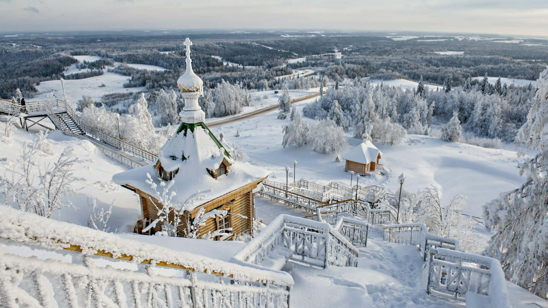 A Snow Covered Hill With A Wooden Church