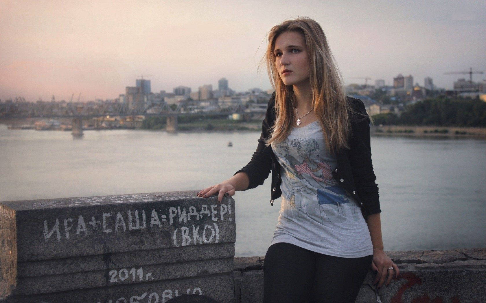 En russisk pige sidder på en betonvæg. Wallpaper