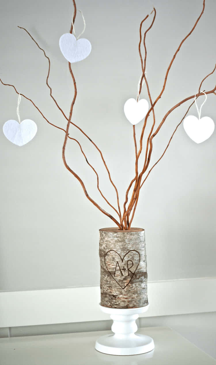 A Vase With Branches And Hearts On It Wallpaper