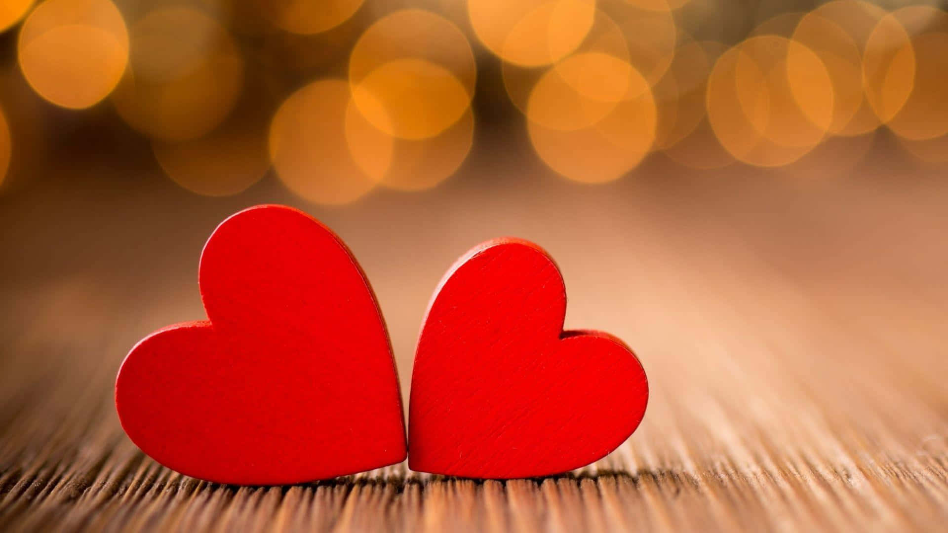 To røde hjerter på et træbord med bokeh-baggrund Wallpaper