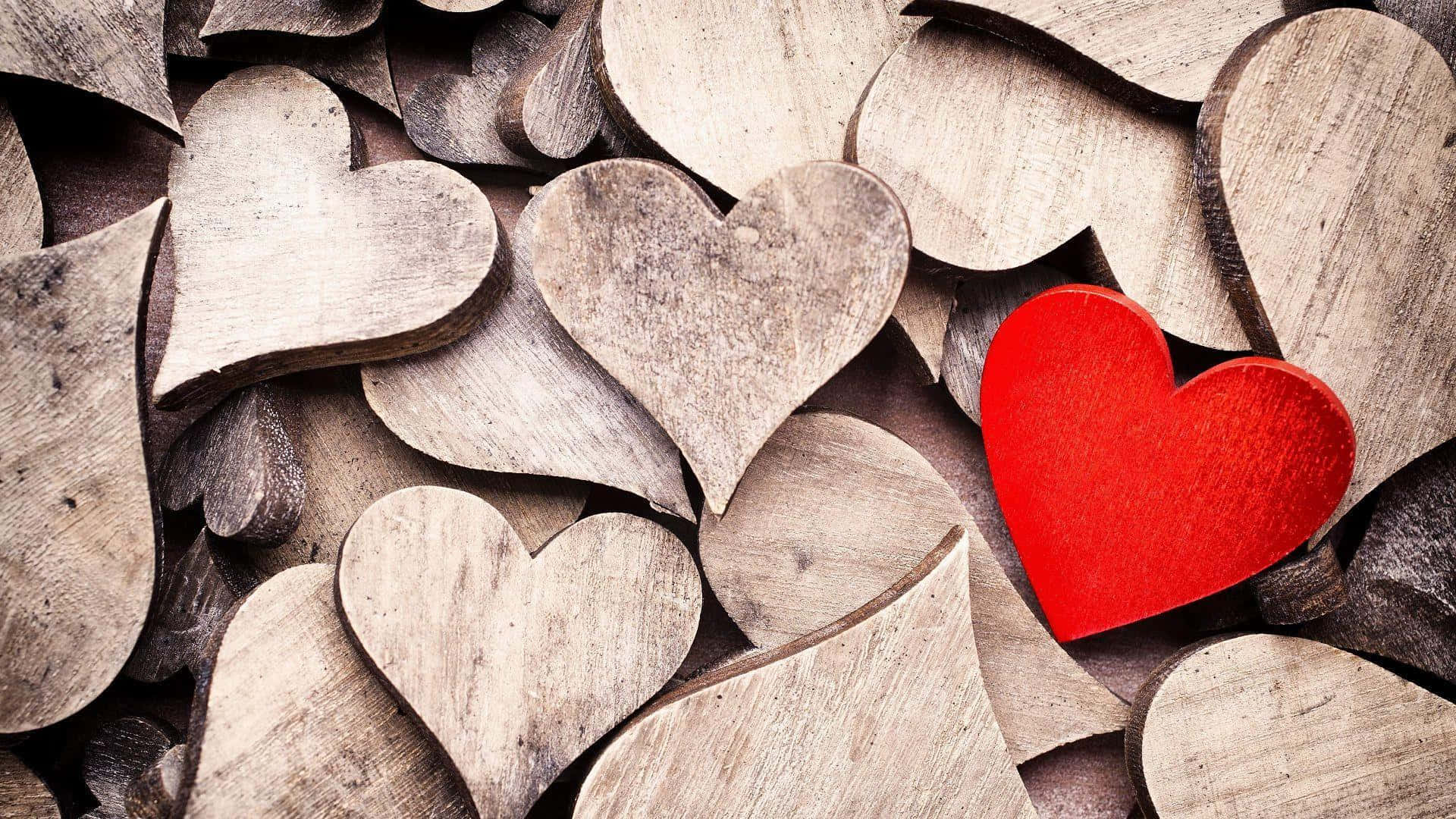 Et rødt hjerte er i midten af et bunke af træhjerter Wallpaper