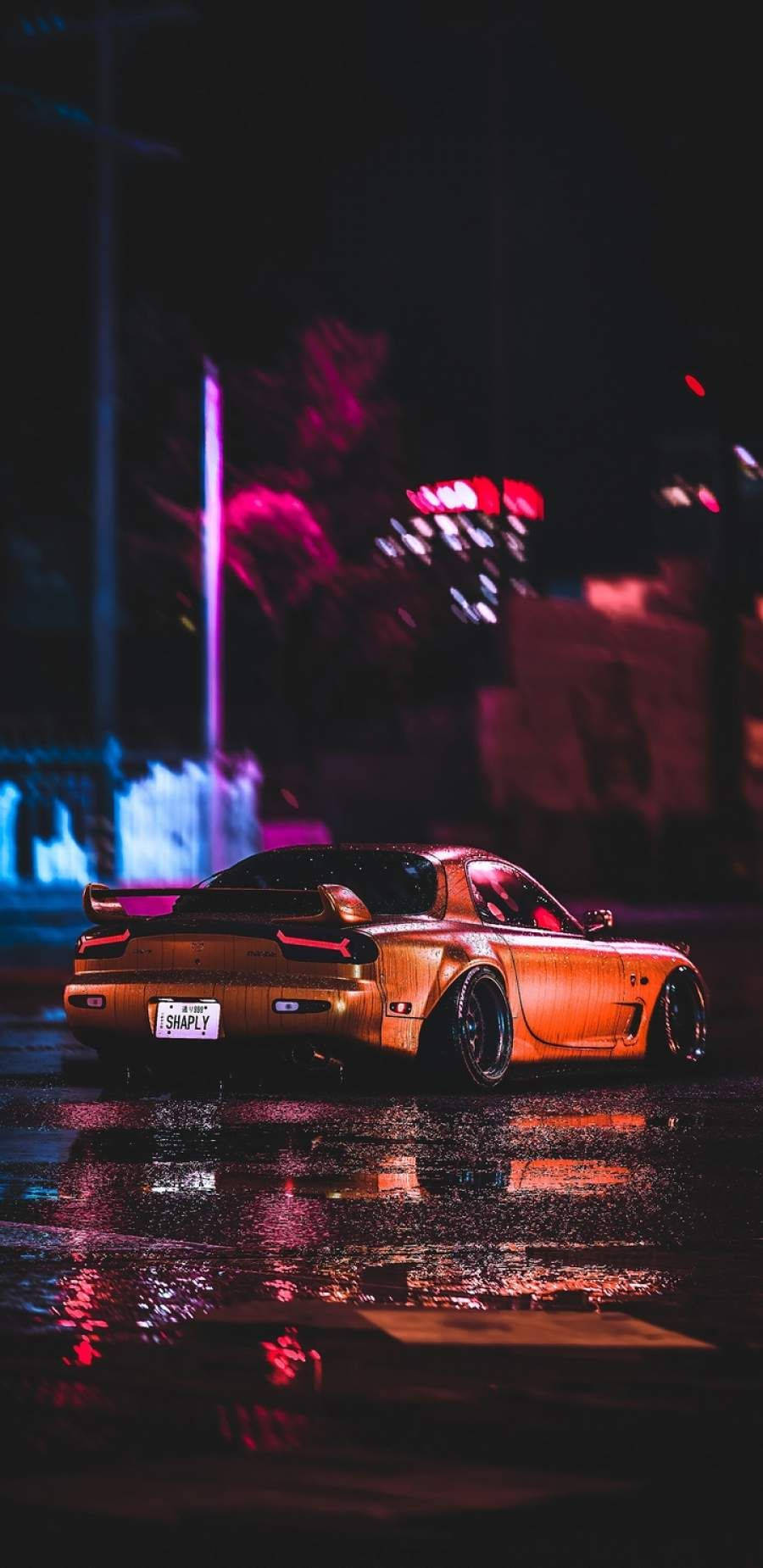 a car driving down the street at night Wallpaper