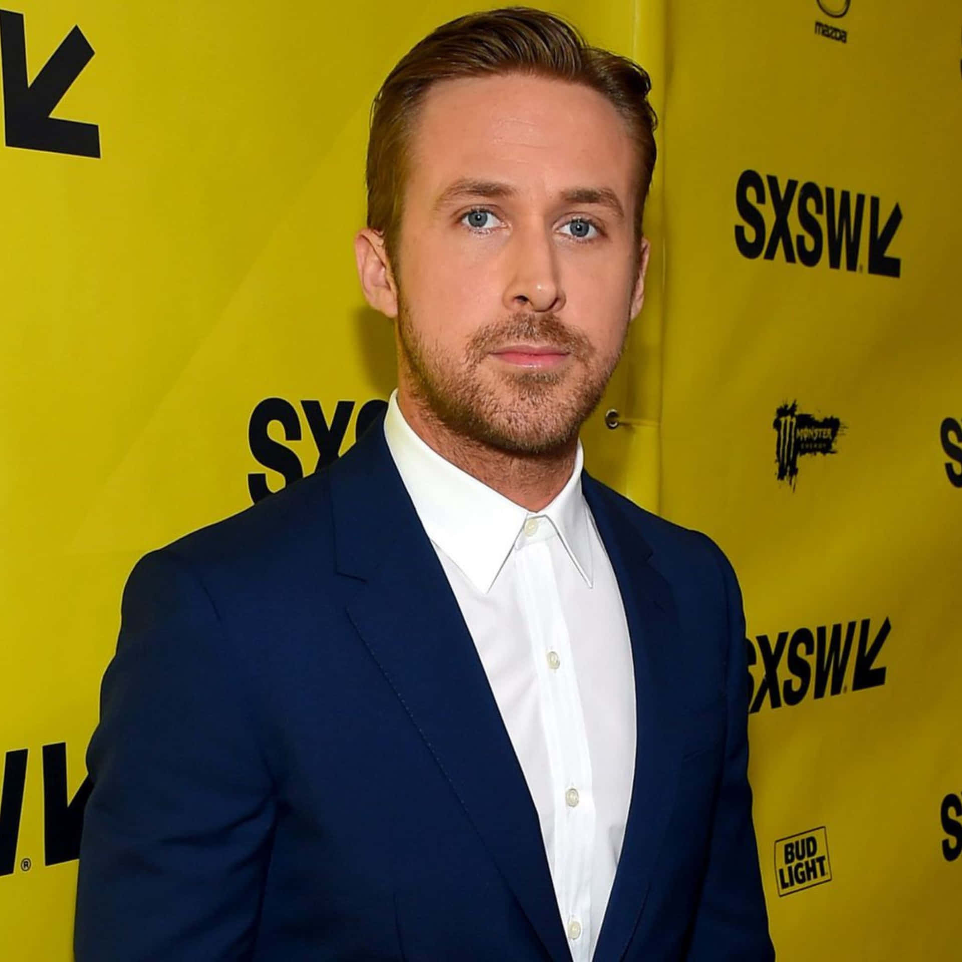 Ryan Gosling Puvussa Keltaisella Taustalla Taustakuva