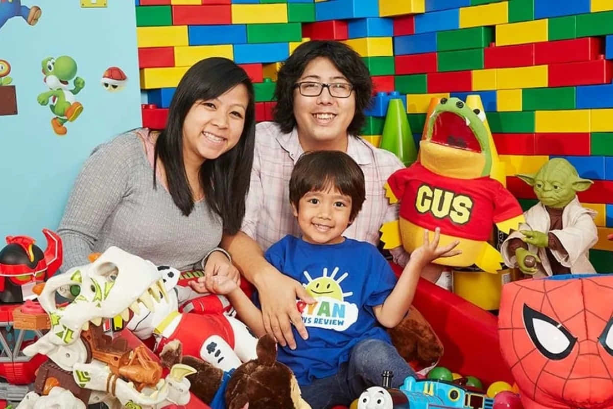 Einefamilie Posiert Mit Einem Kind Und Stofftieren. Wallpaper