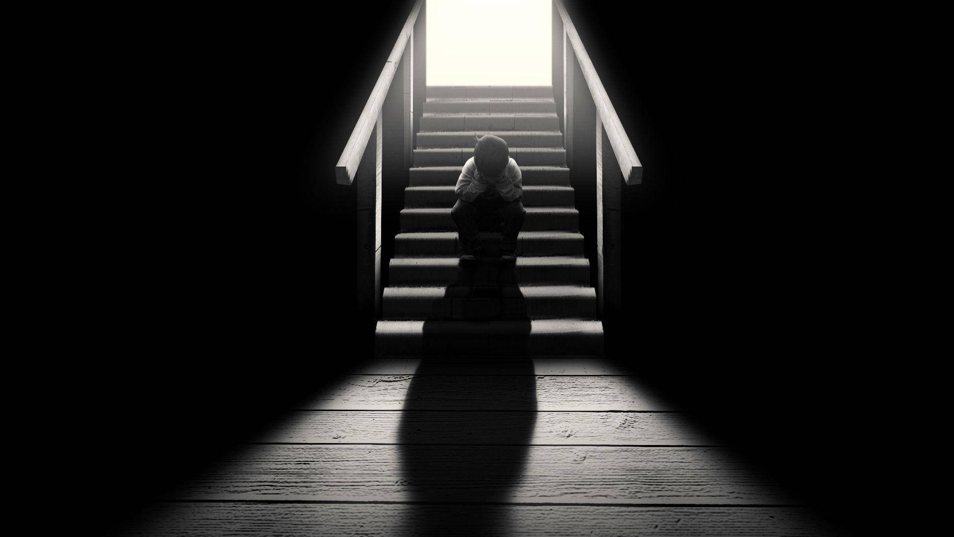 Dark Loneliness: A Solitary Figure on a Staircase Wallpaper