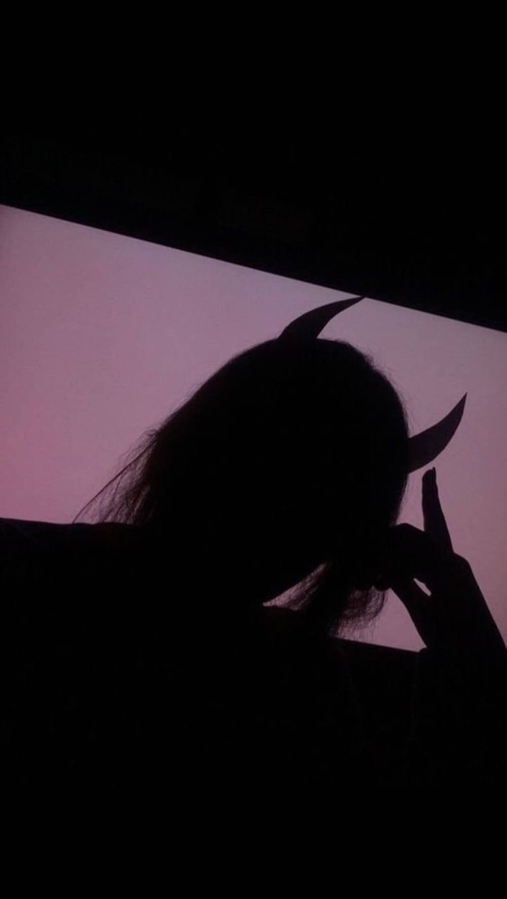 A Silhouette Of A Woman With Horns On Her Head Wallpaper