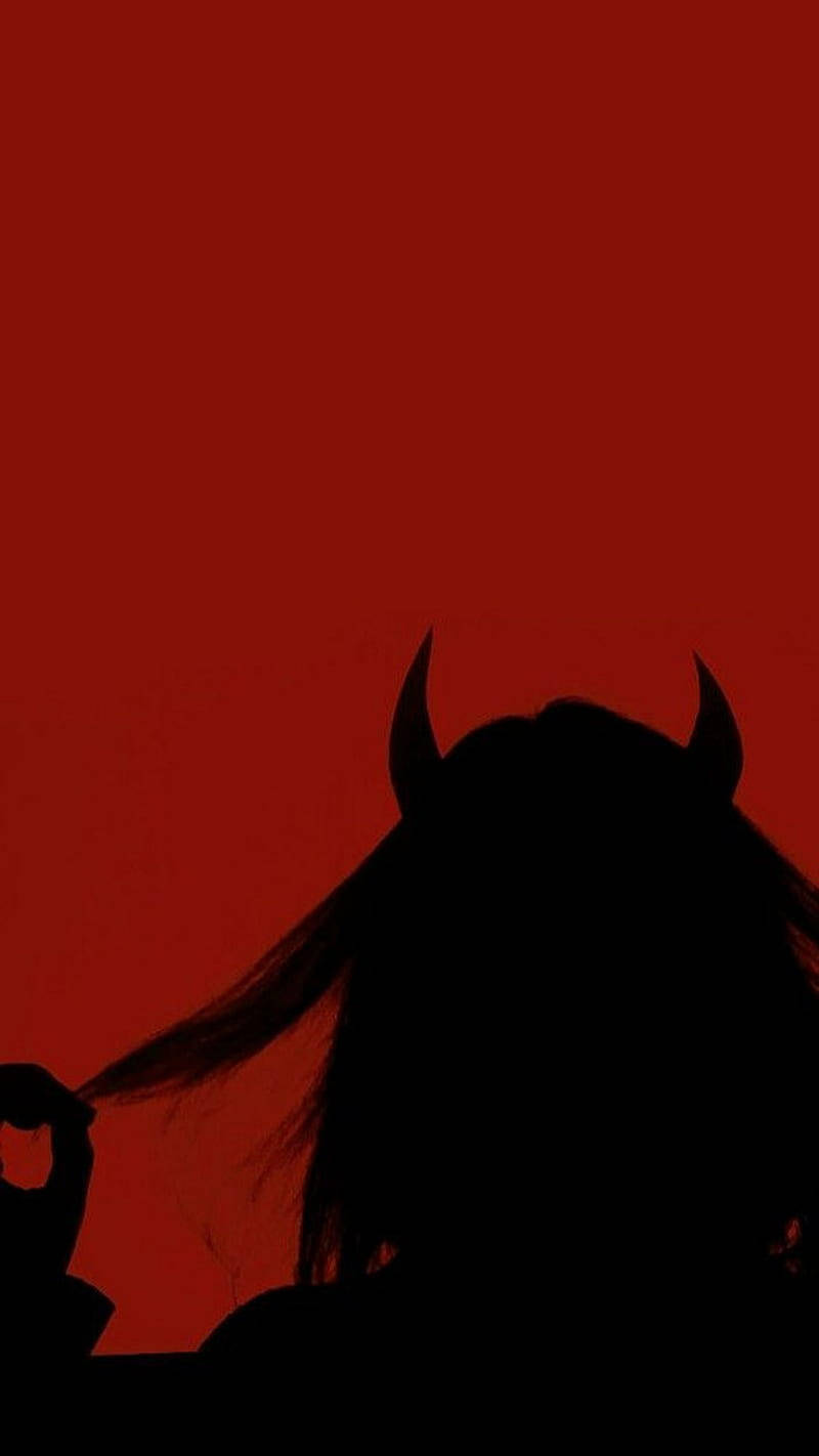 A Silhouette Of A Woman With Horns And A Red Background Wallpaper