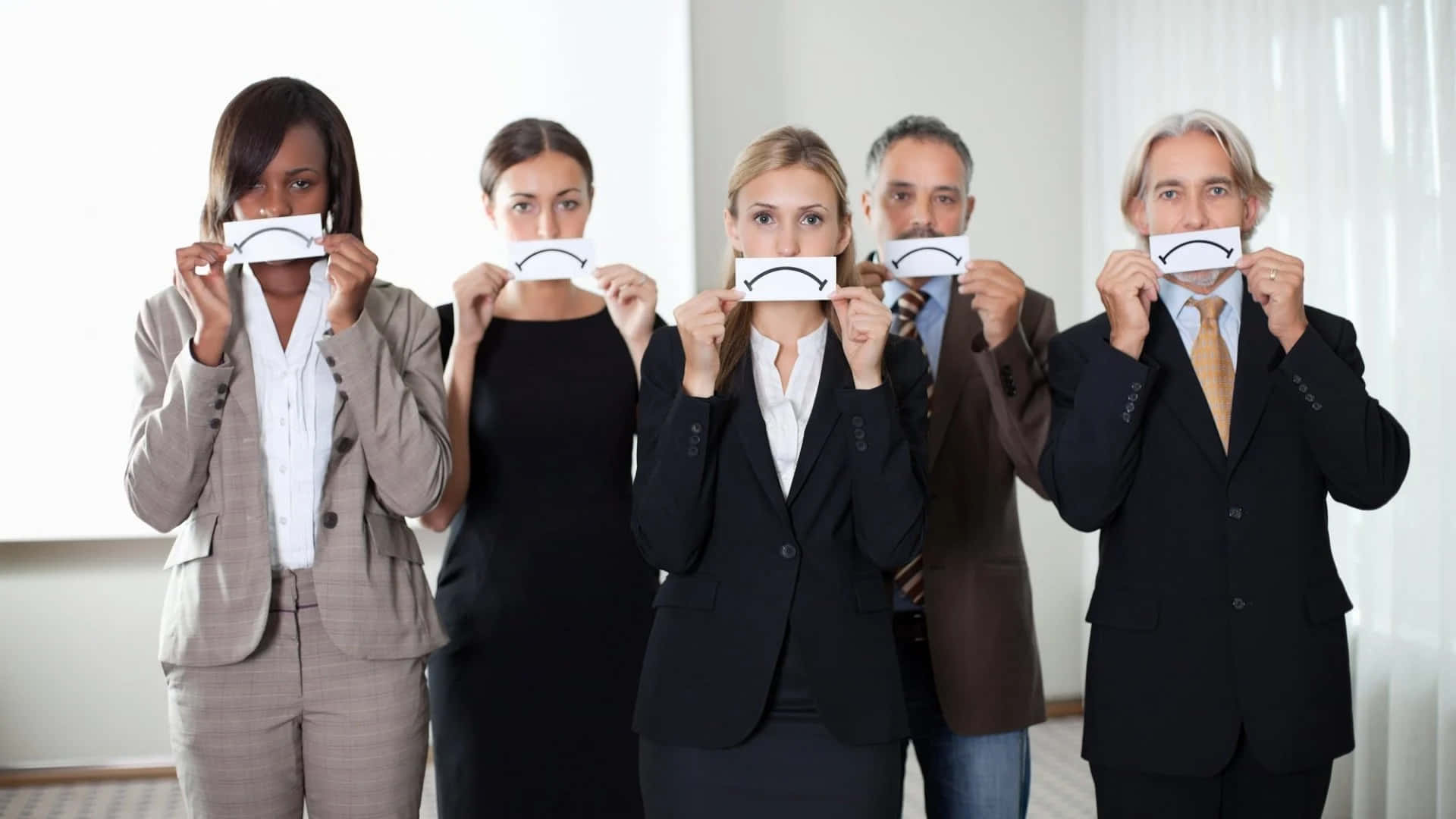 Business People Holding Up Paper With Sad Faces