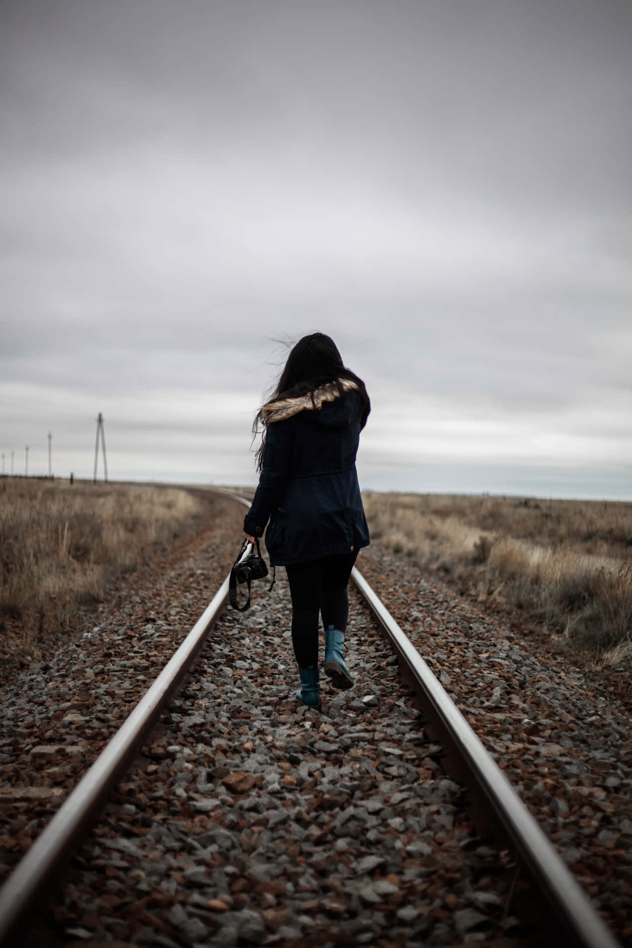 A Woman Walking On Train Tracks Wallpaper