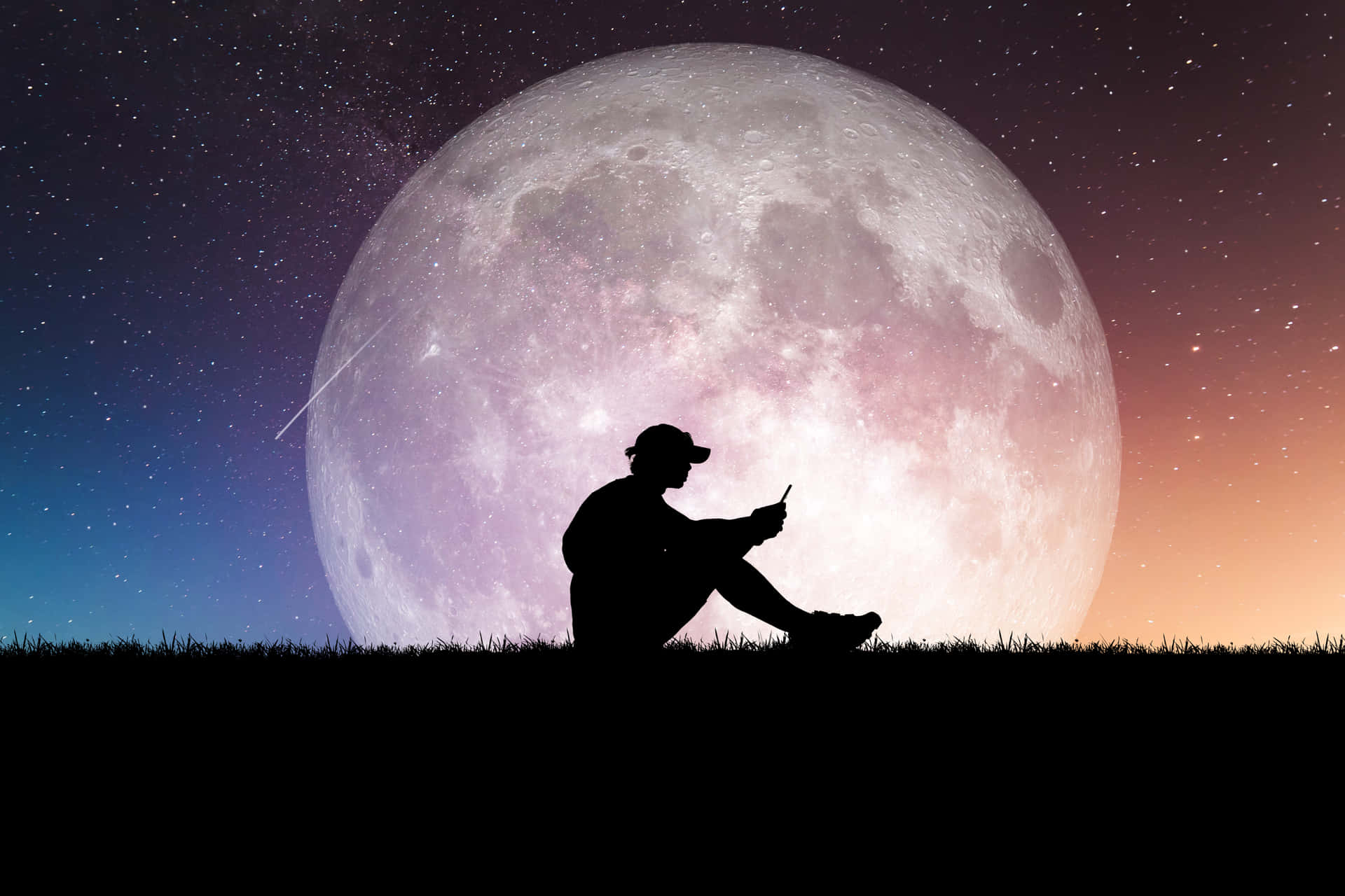 Unhombre Sentado En El Suelo Con Una Luna Llena Detrás De Él Fondo de pantalla
