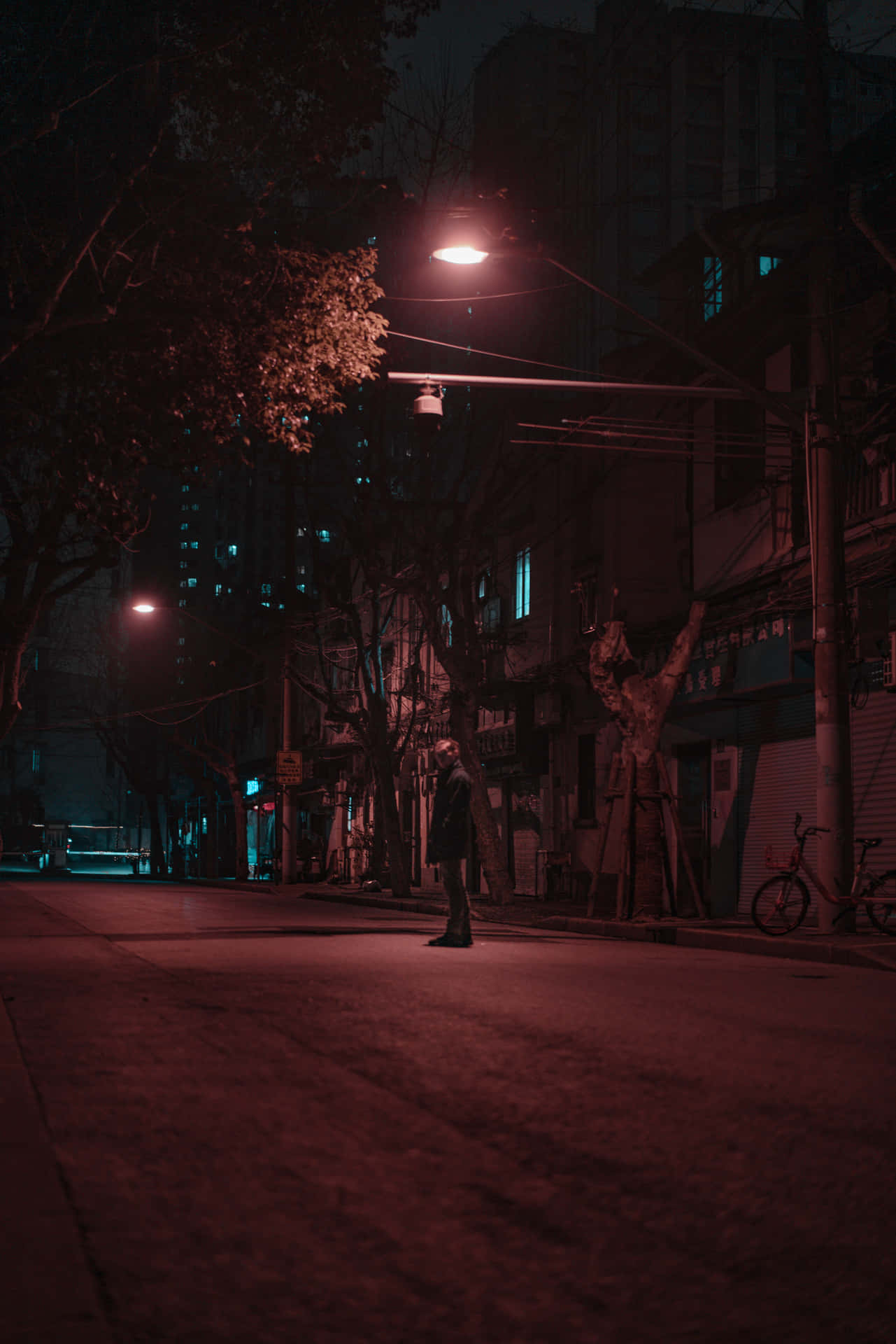 En mand står på en gade om natten. Wallpaper