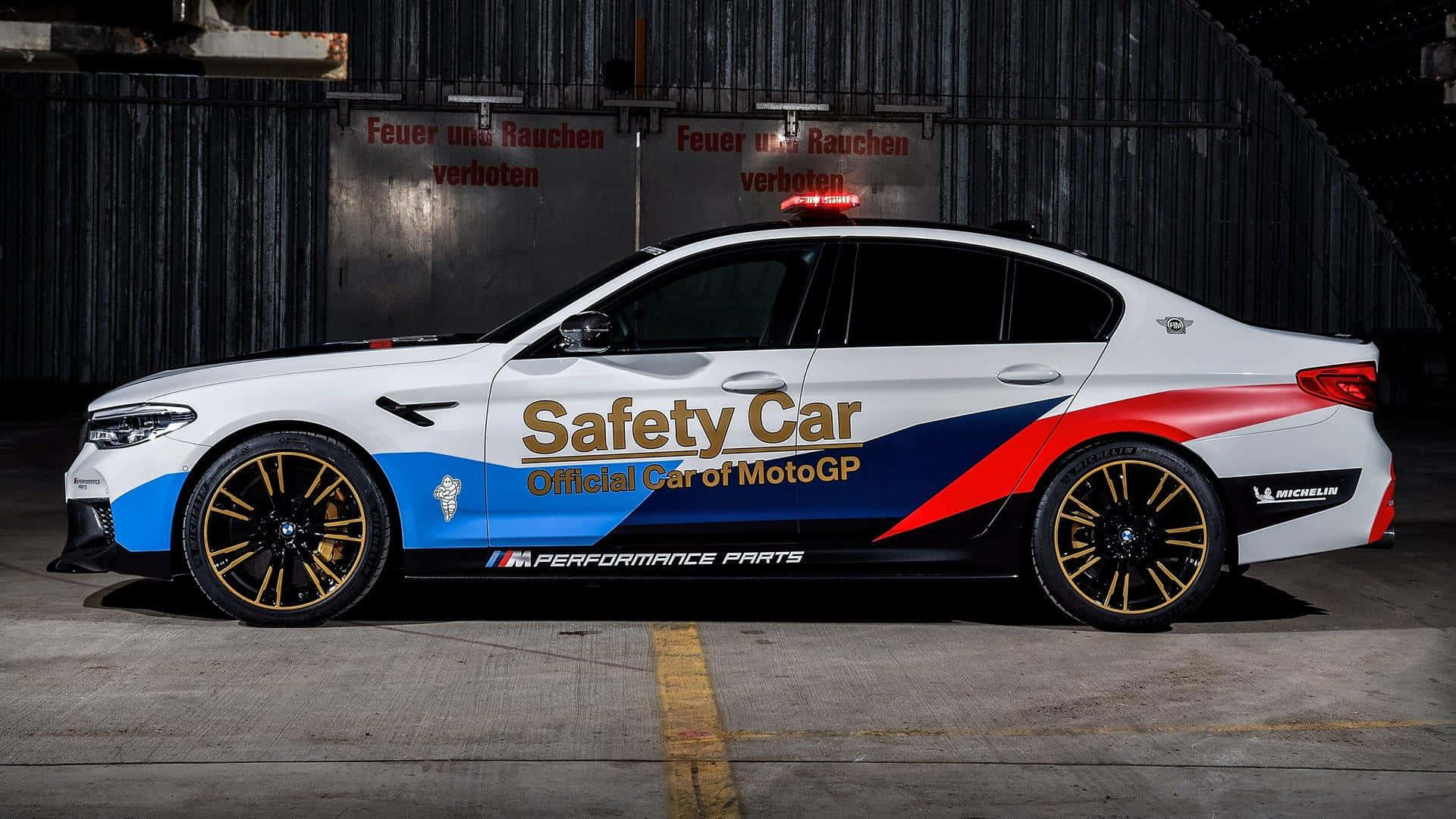 A vibrant safety car on the racetrack ensuring the security of drivers Wallpaper