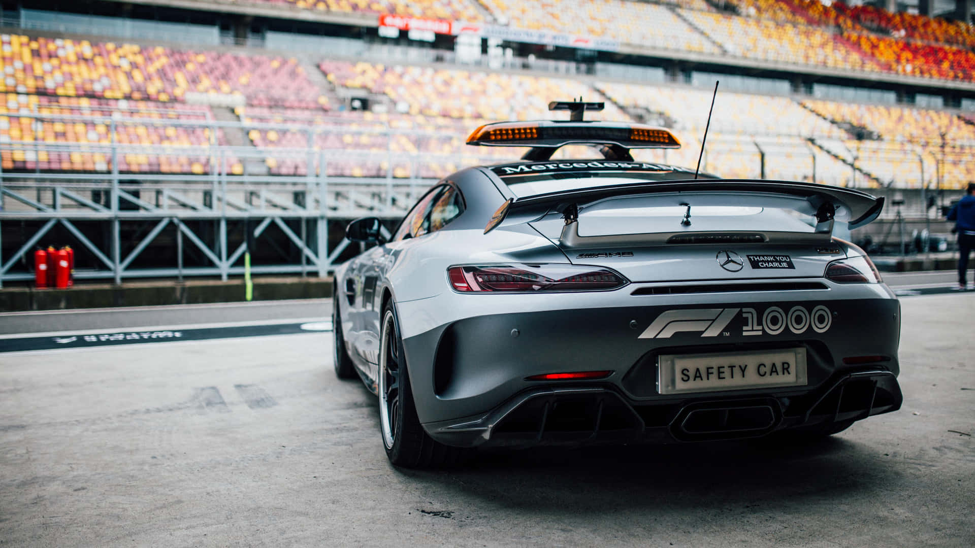 A sleek safety car leading the race on a high-speed track Wallpaper