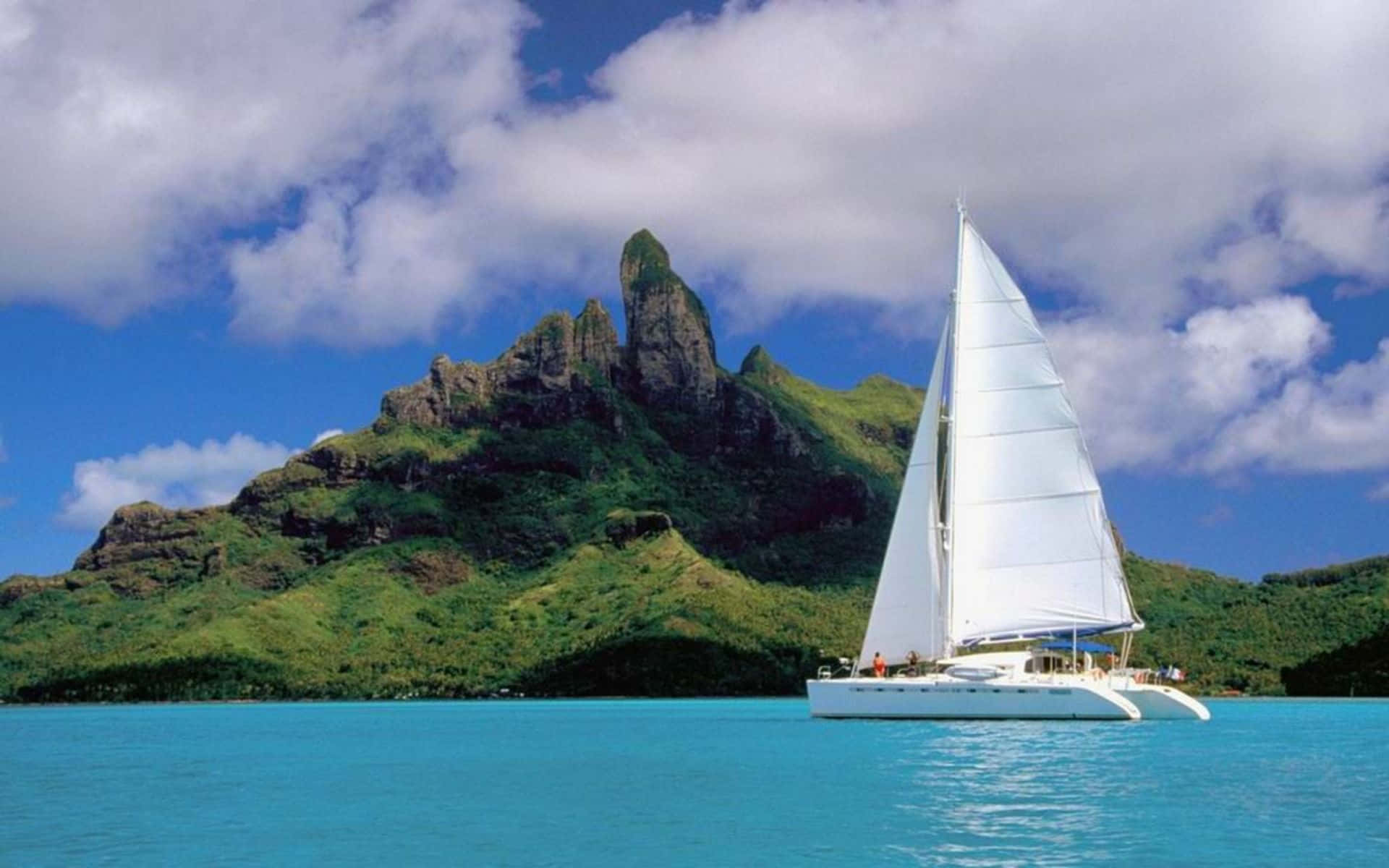 A graceful white sailboat gliding across a crystal-blue lake