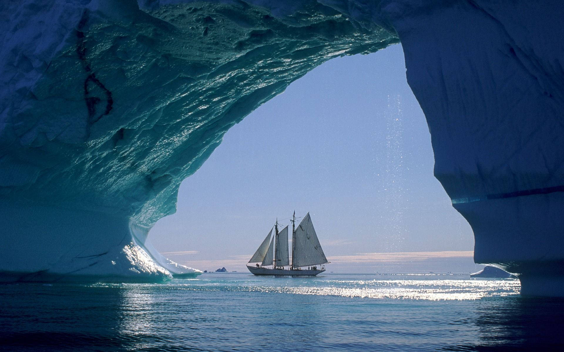 Navegandobajo El Arco De Un Iceberg. Fondo de pantalla