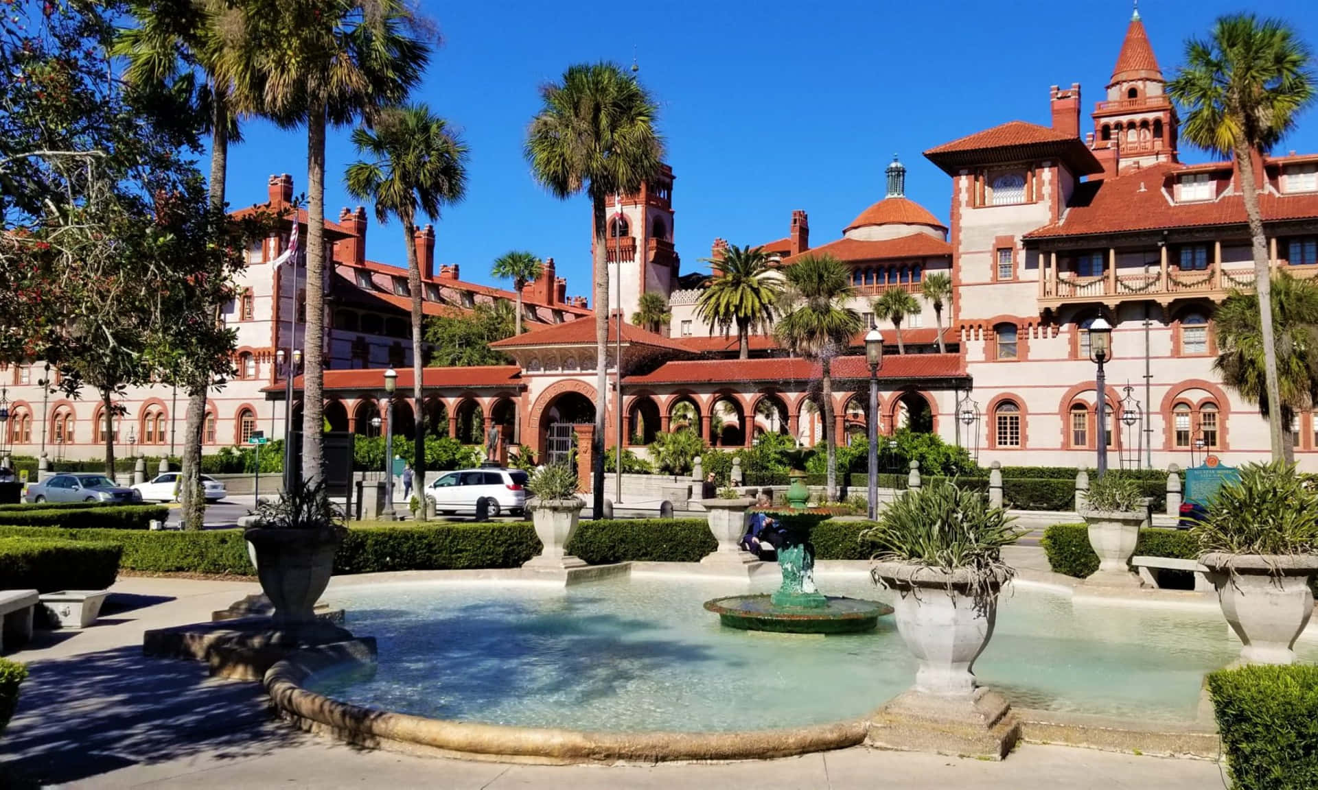 A Large Building With Fountains And Palm Trees