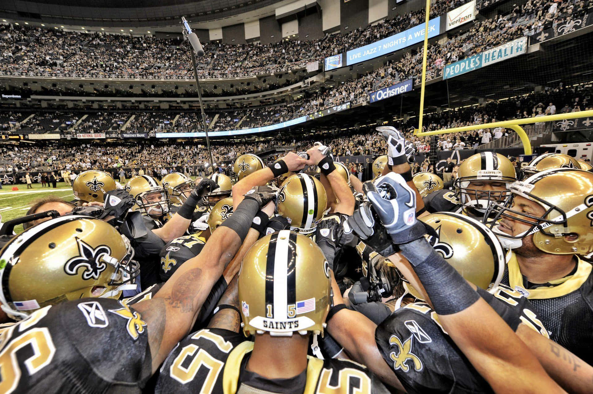 The New Orleans Saints Huddle In The Middle Of The Field