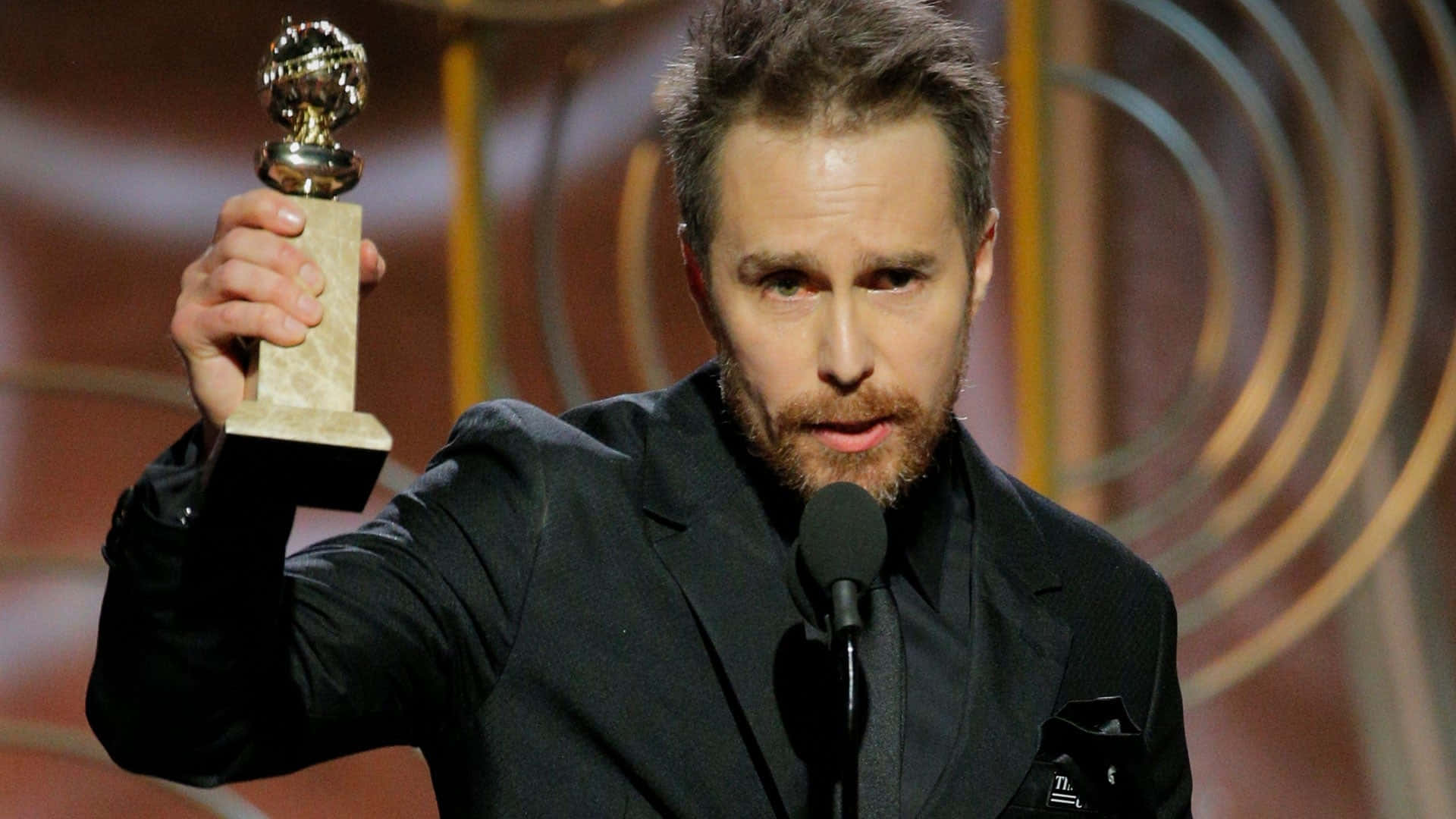 Sam Rockwell exuding charm with his Golden Globe Trophy Wallpaper