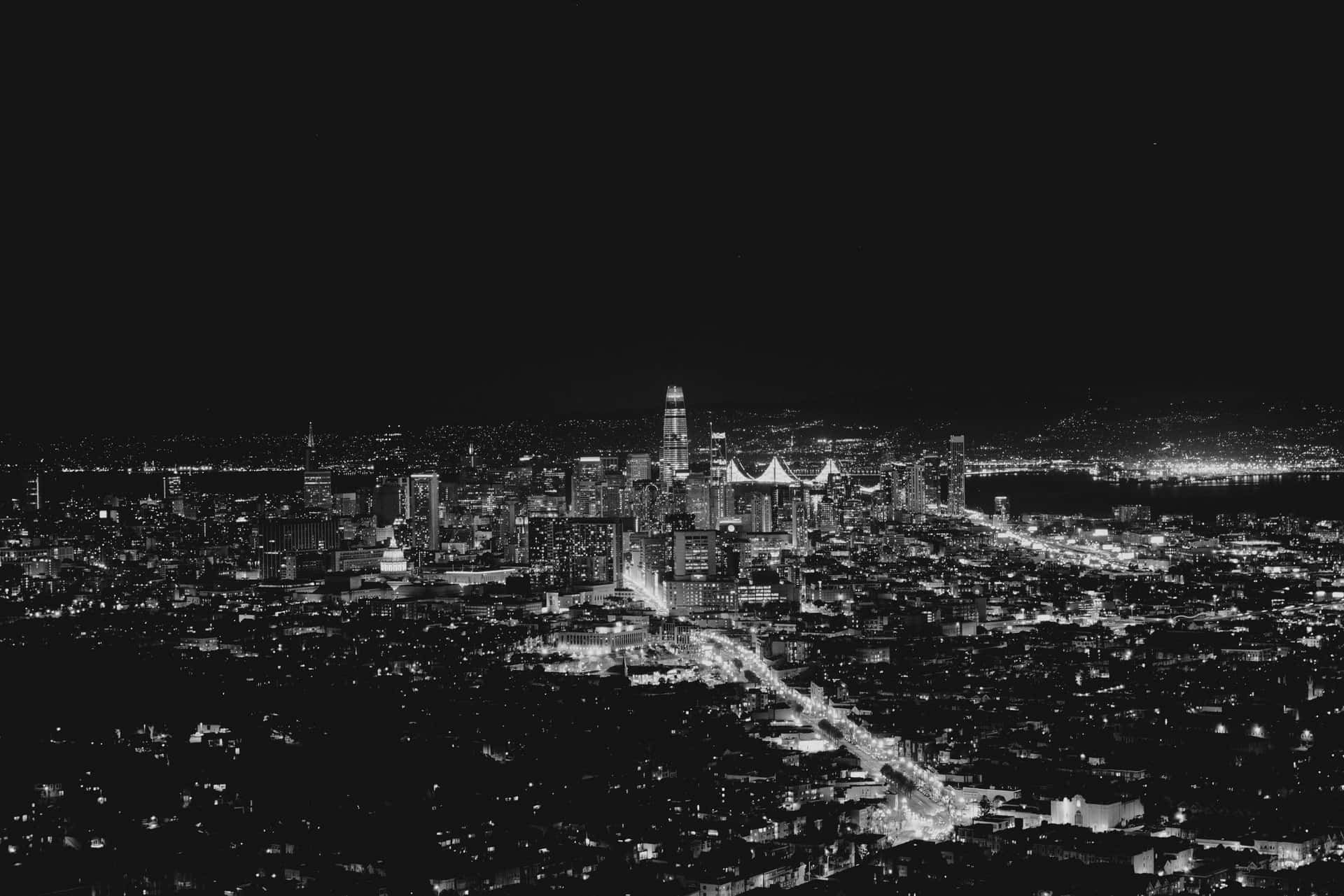A Black And White Photo Of A City At Night Wallpaper
