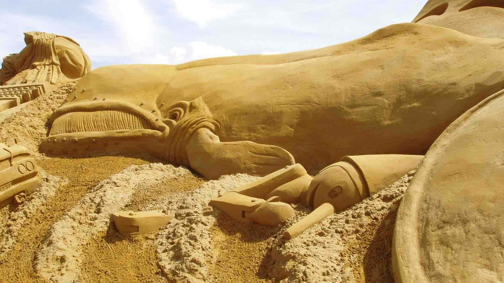 A Sand Sculpture Of A Lion And A Giraffe