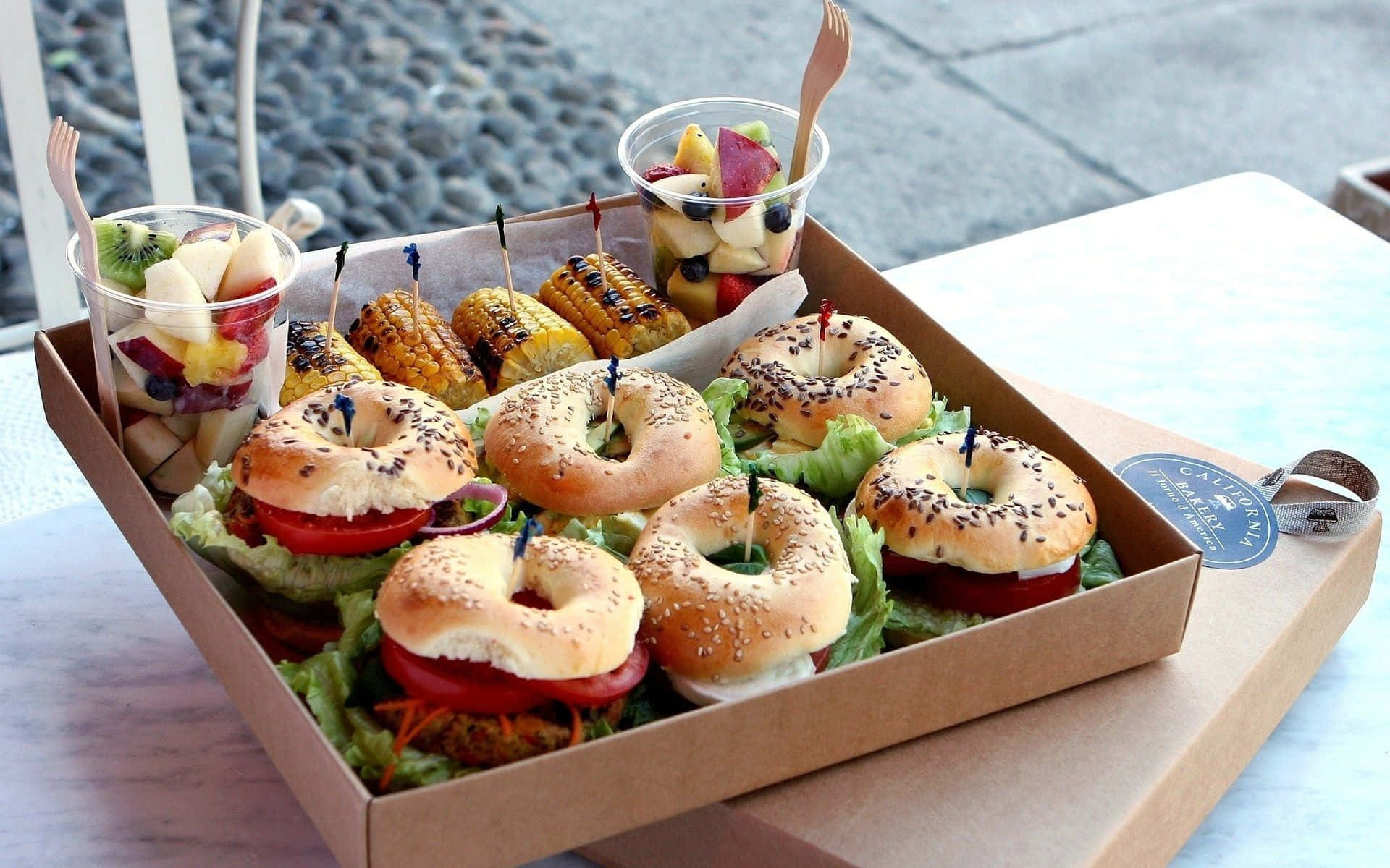 A Box Of Bagels With A Variety Of Toppings