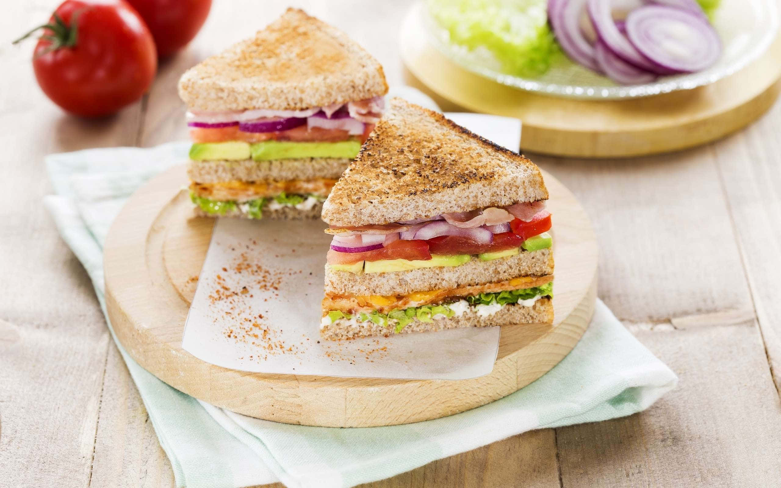 A Sandwich With Tomatoes, Lettuce, And Onions