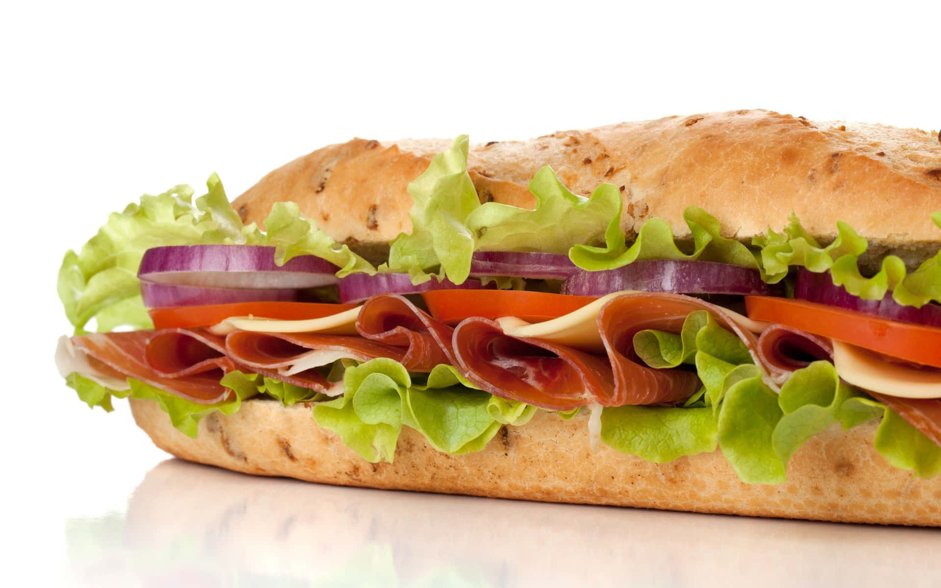 A Sandwich With Meat, Lettuce, Tomatoes, And Onions