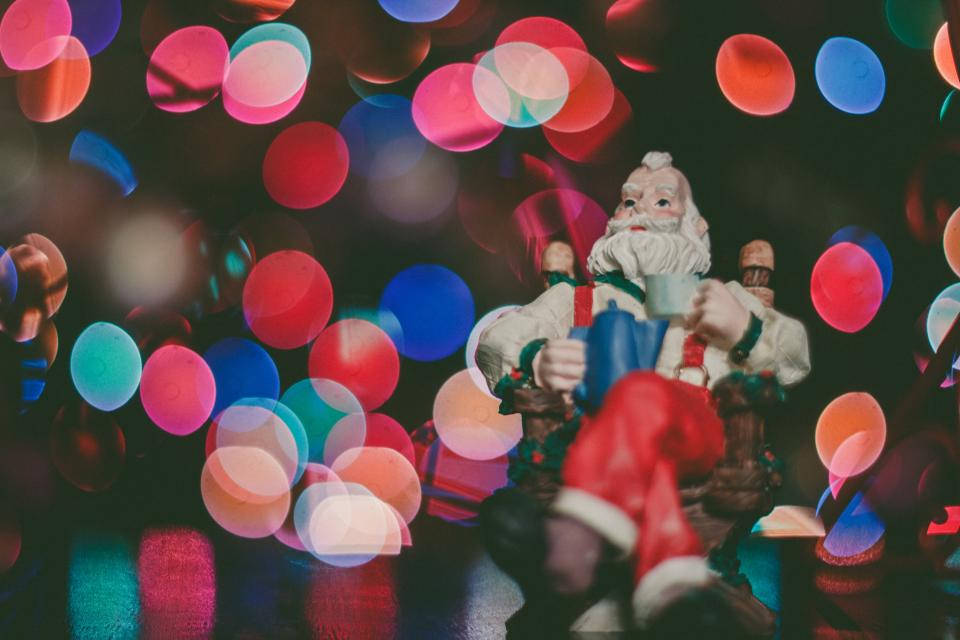Santa Figurine And Colorful Christmas Lights Wallpaper