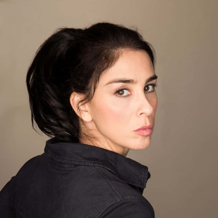 Sarah Silverman striking a pose on a red background Wallpaper