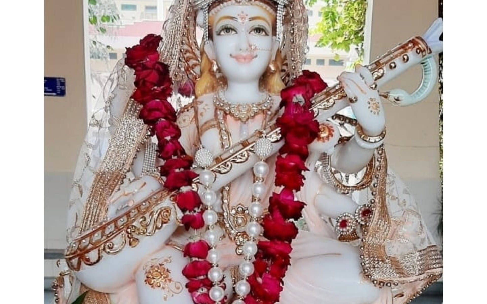 Saraswati Hvid Statue Røde Blomster Wallpaper