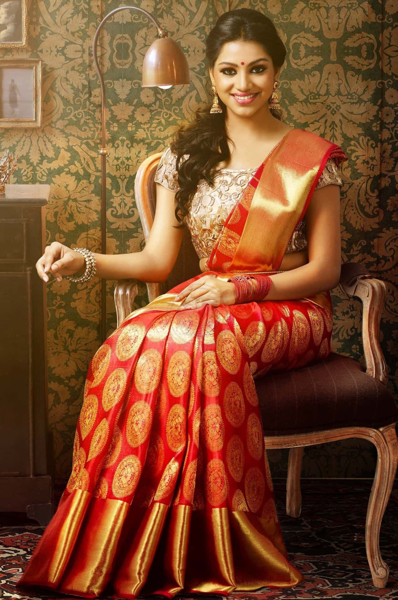 A Beautiful Woman In A Red Sari Sitting In A Chair