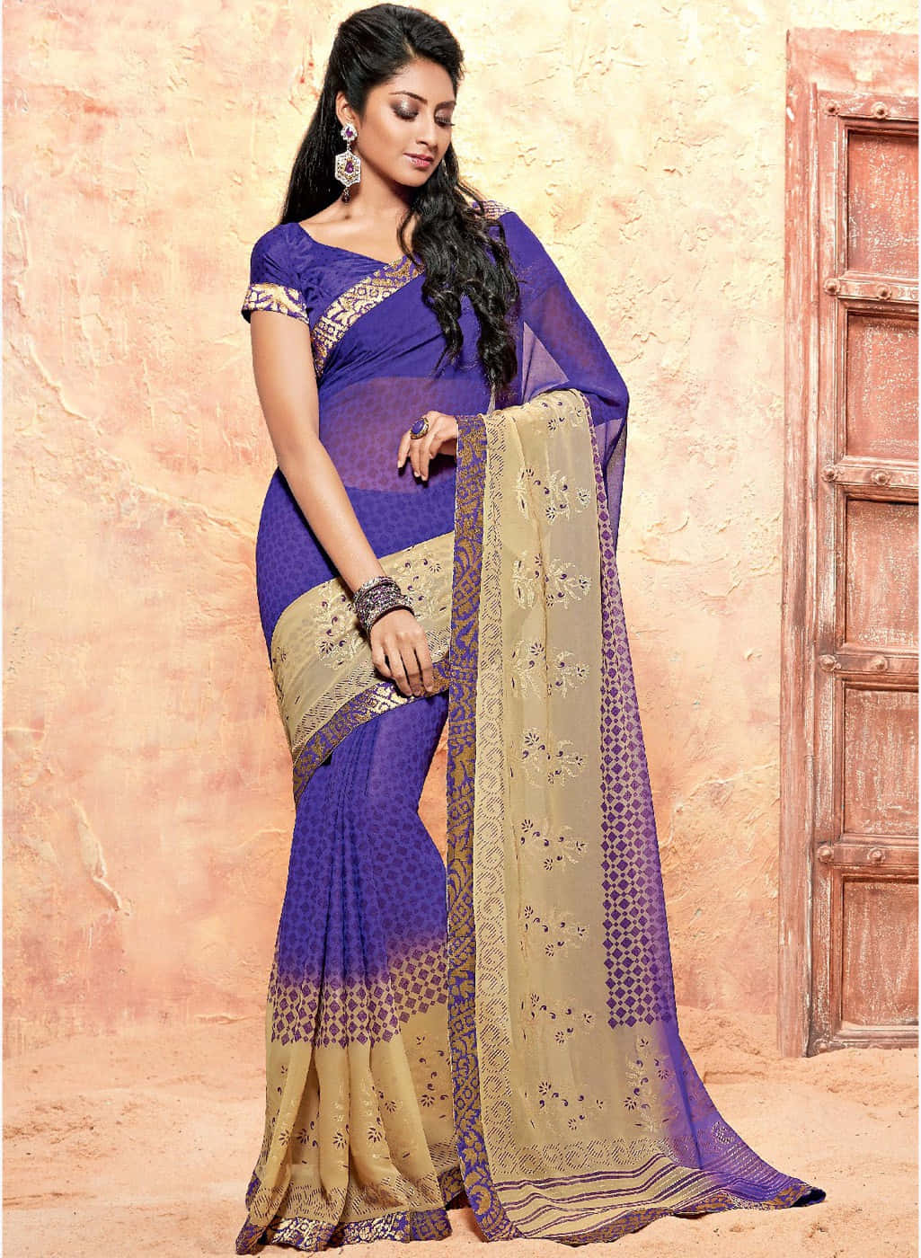 A Beautiful Woman In A Blue And Gold Saree