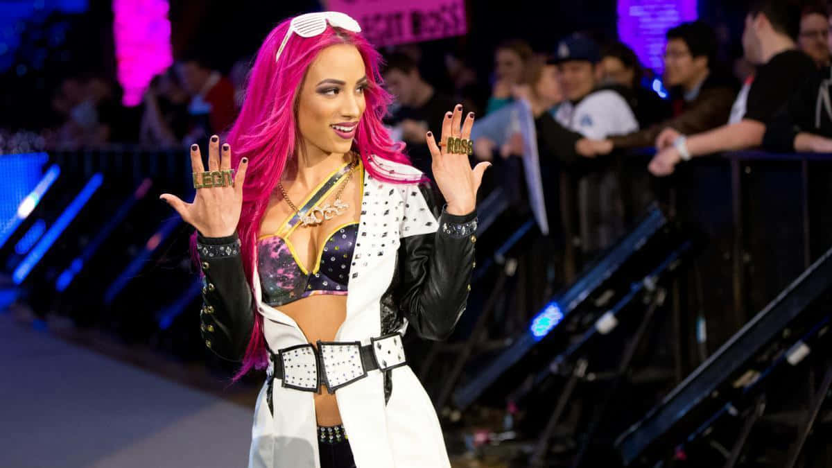 A Woman With Pink Hair And Black Outfit Is Standing On A Stage Wallpaper