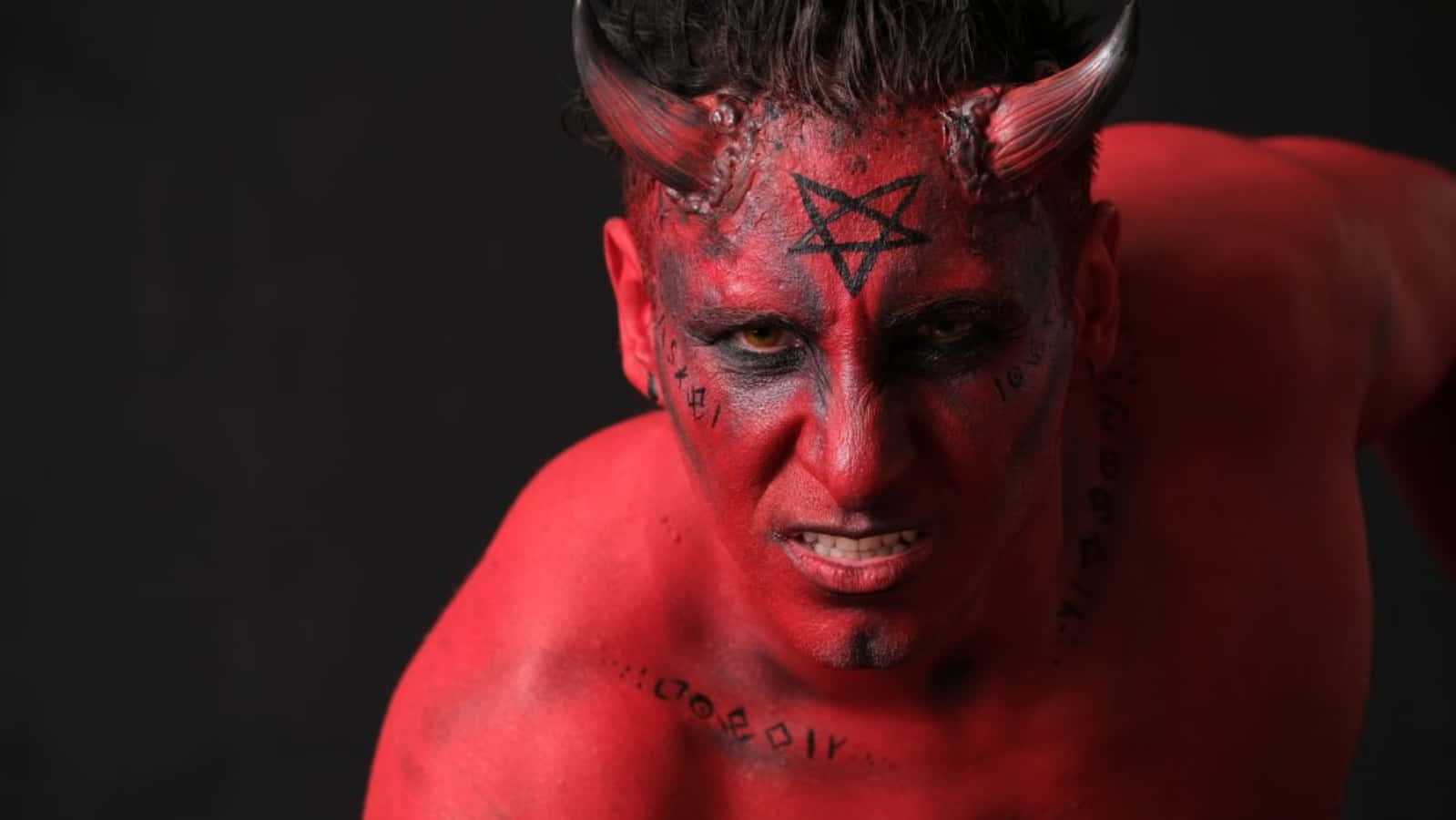 A Man With Red Devil Makeup On His Face