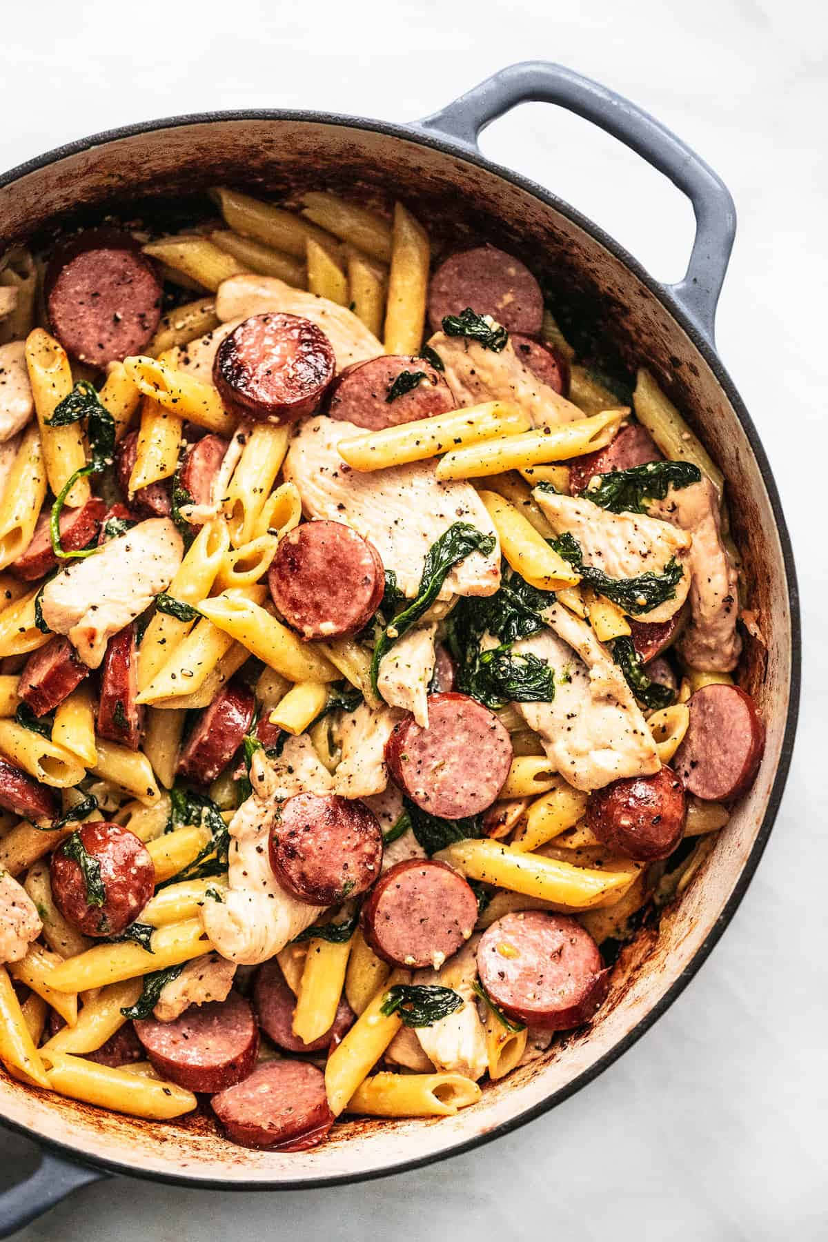 A Skillet Filled With Pasta And Sausage