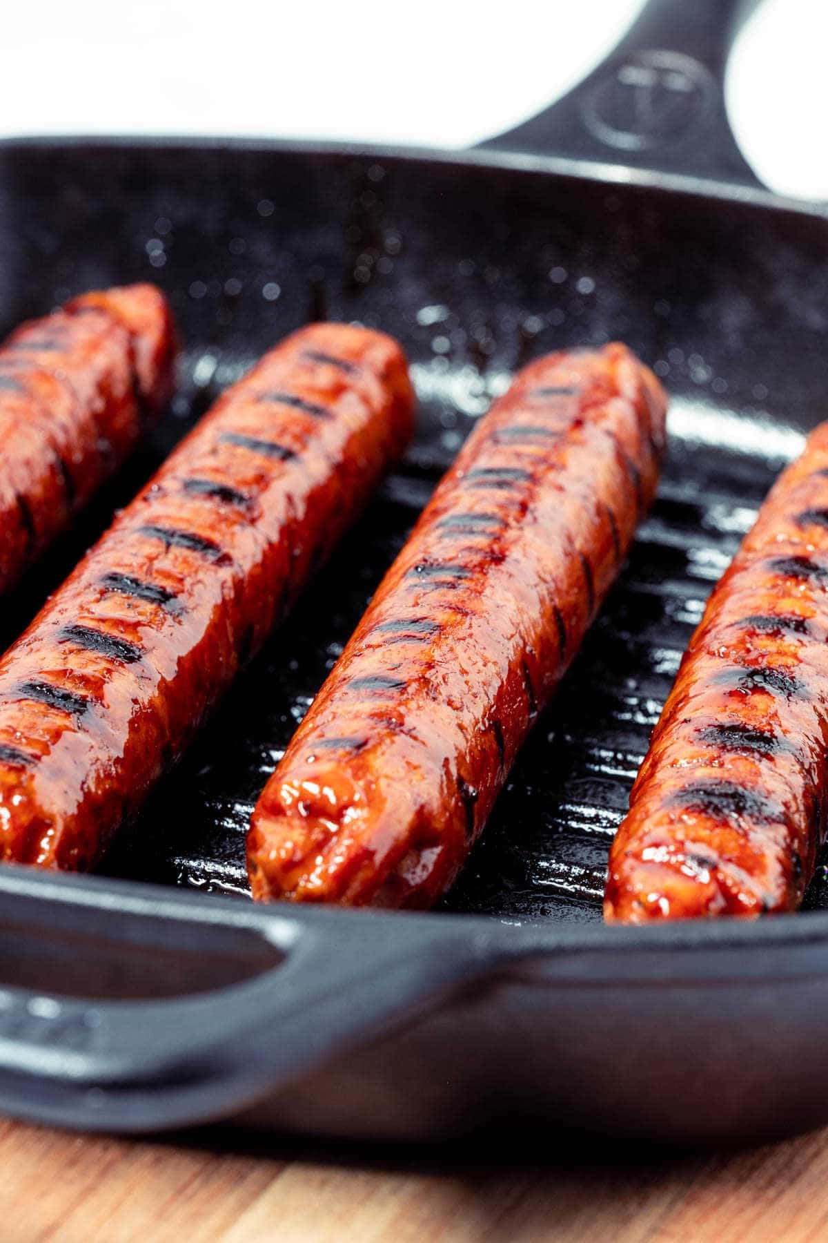 A Cast Iron Skillet With A Group Of Hot Dogs