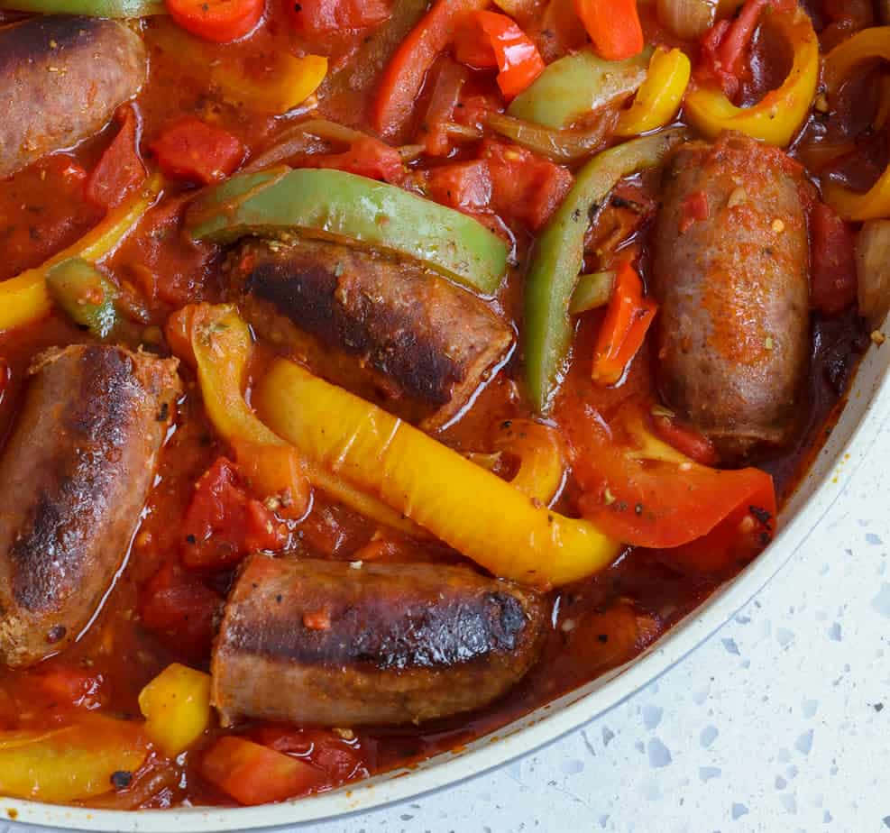 A Pan With Sausages And Peppers In It