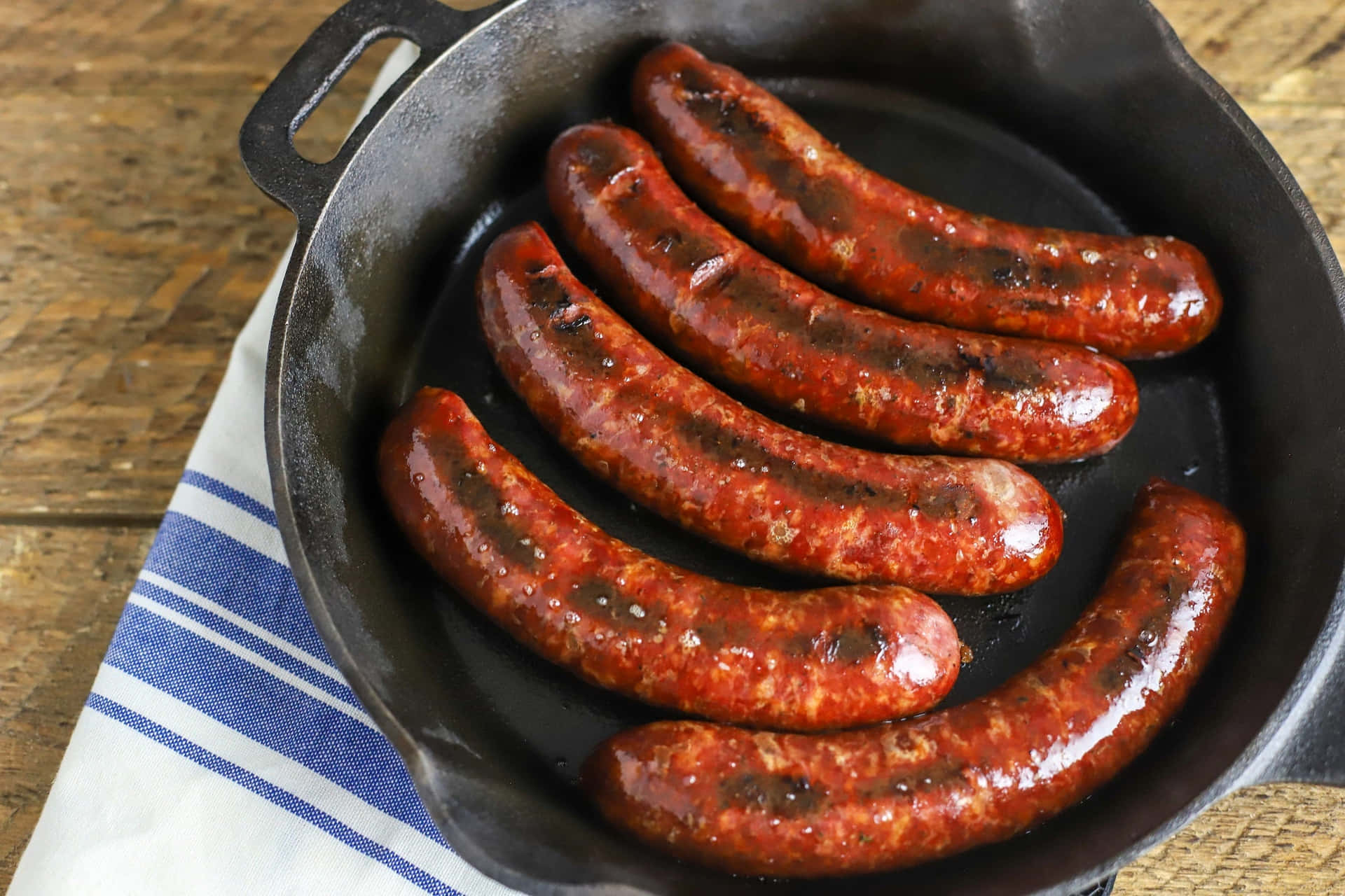 Sausages In A Skillet On A Wooden Table