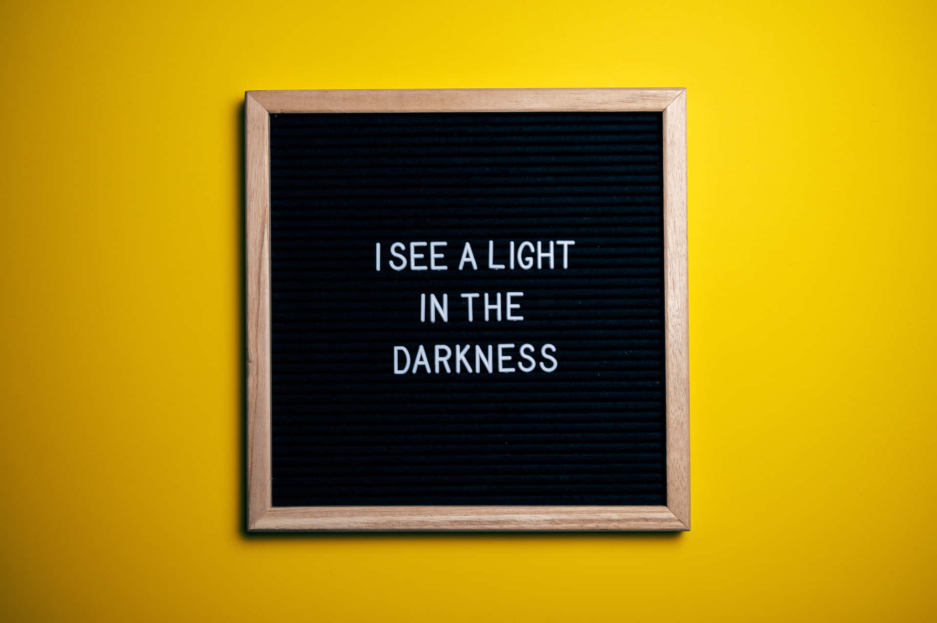 En sort tavle med ordene ses et lys i mørket Wallpaper