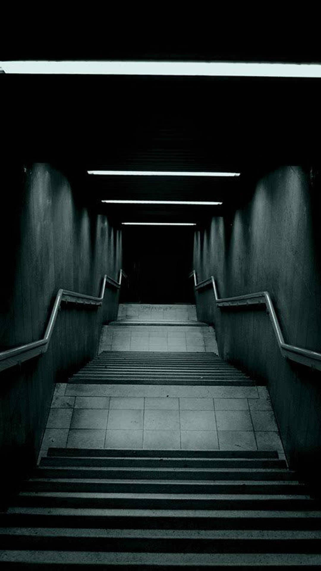 A Dark Hallway With Stairs Leading Down To A Dark Room Wallpaper