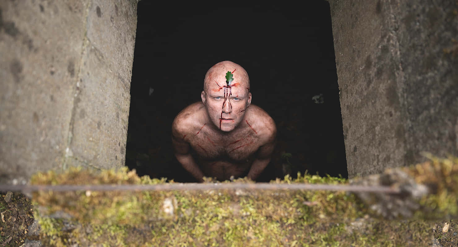 a man with a red head in a tunnel