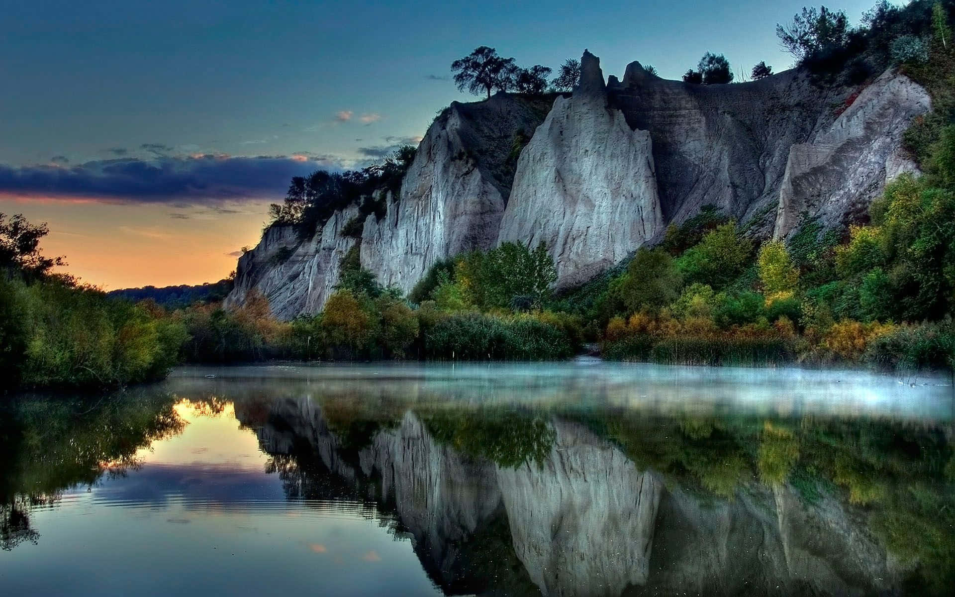 A Lake With A Rocky Cliff In The Background
