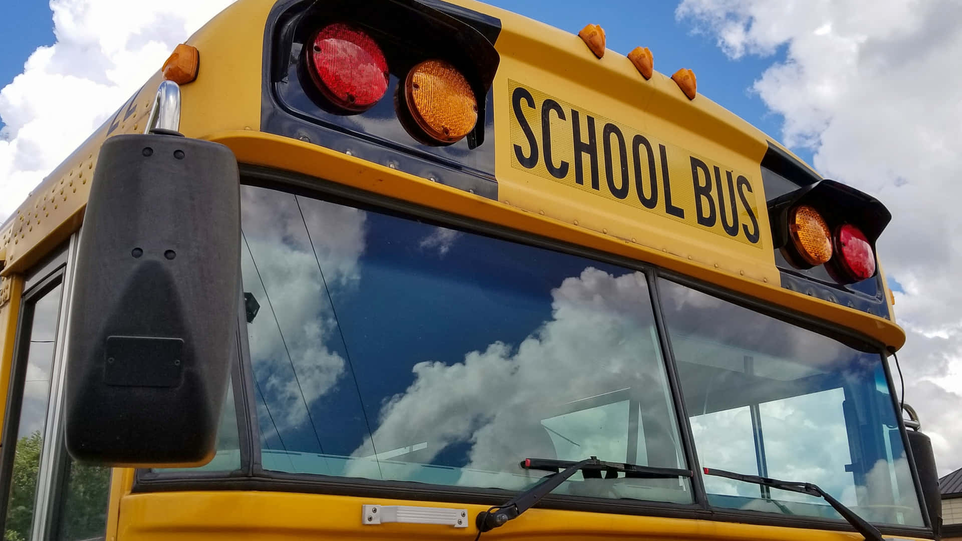 School Bus Front With Blue Sky Reflection Background