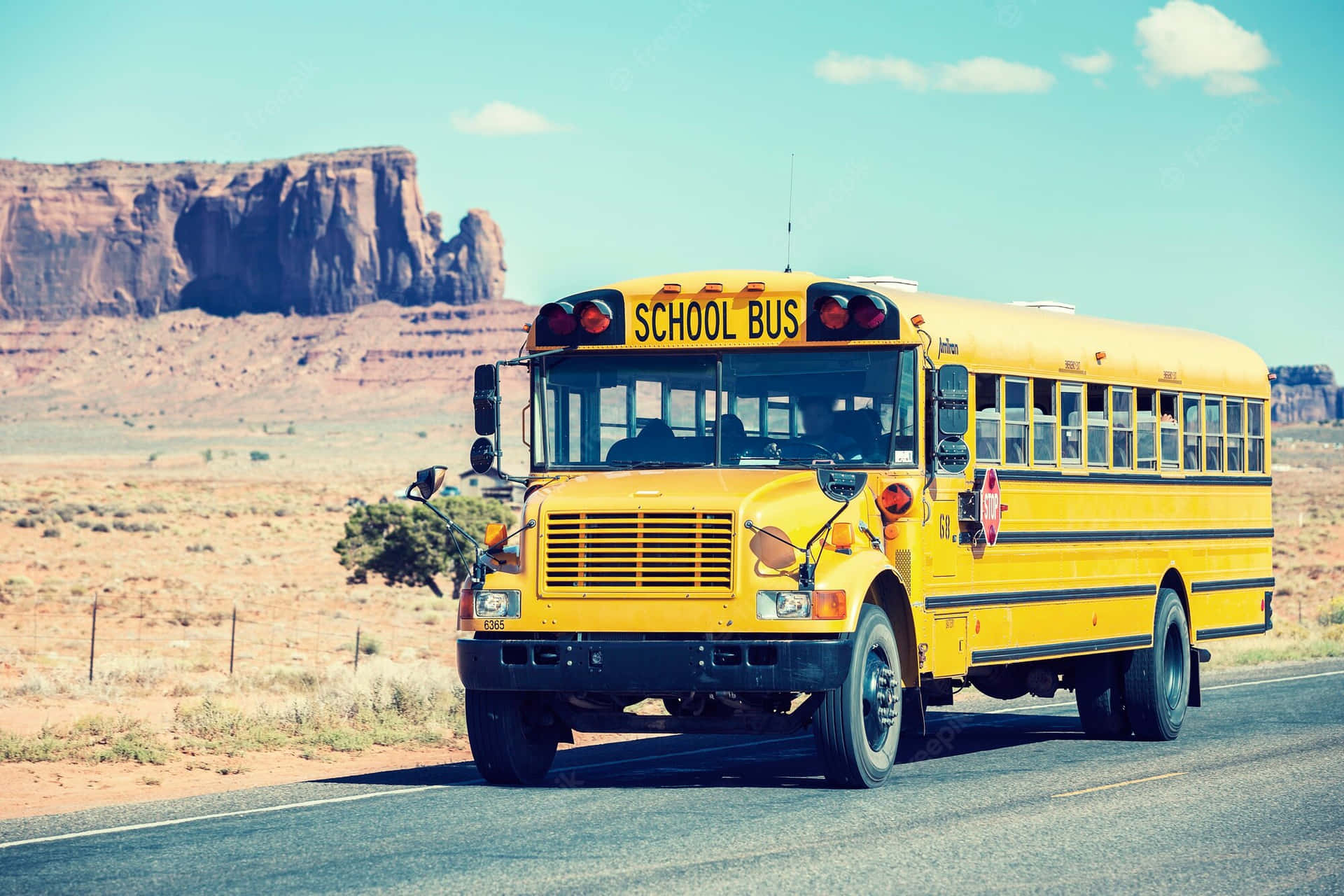 School Bus Traveling Near Monument Valley Wallpaper