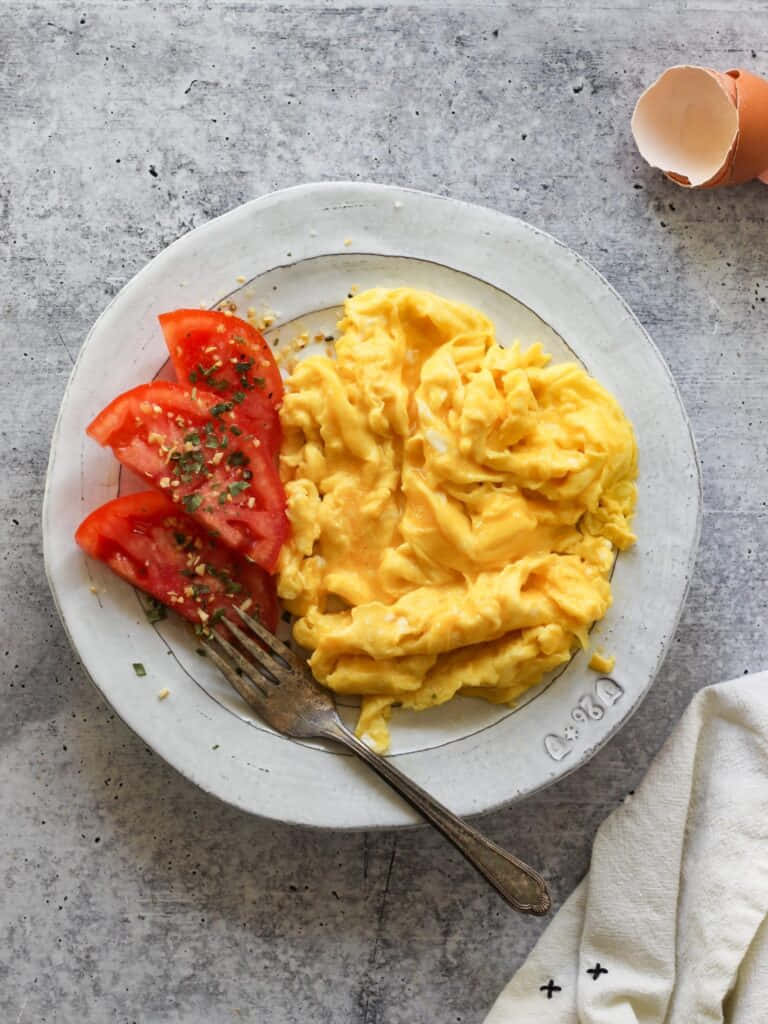Deliciously cooked scrambled eggs with tomatoes, onions and cheese.