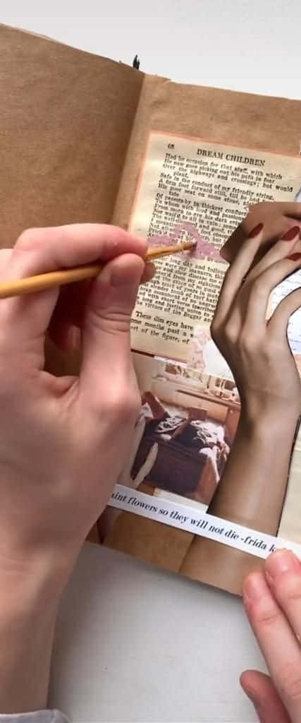 A Person Is Holding An Open Book With A Pencil