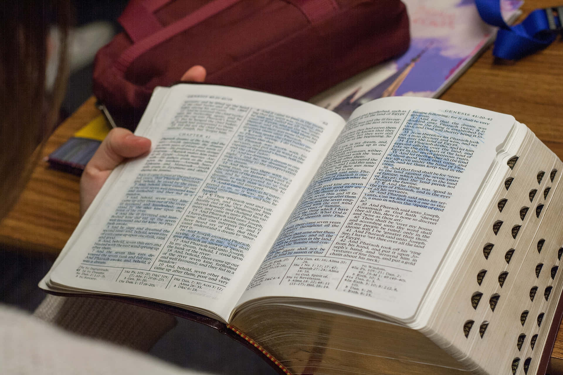 En person læser en bibel ved et skrivebord.