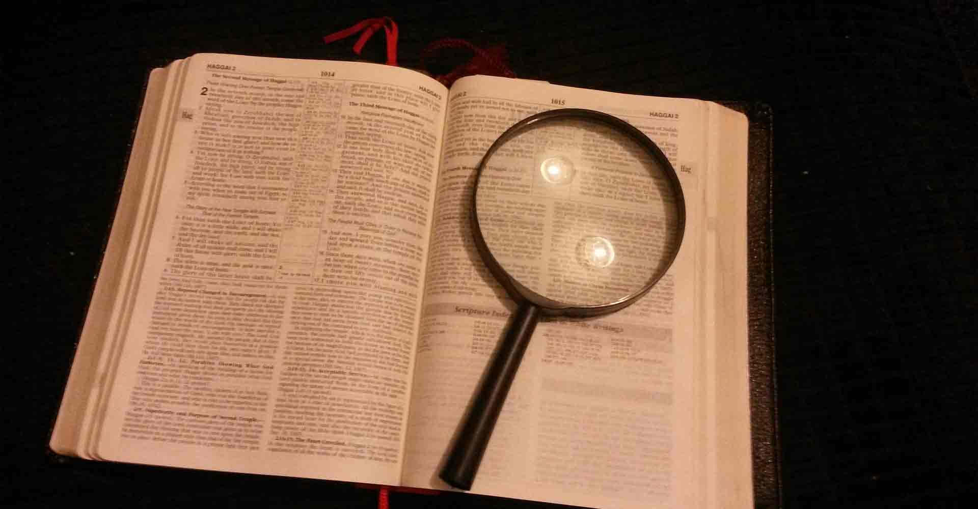 Enförstoringsglas På En Öppen Bibel
