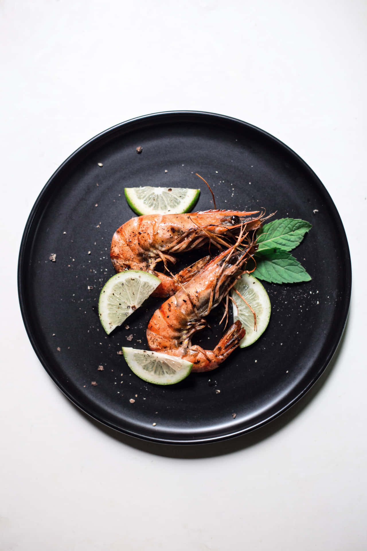Prawns On A Black Plate With Lime Slices